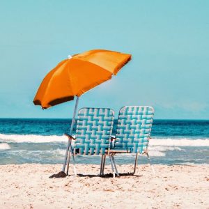 Sonnenschirm und Liegestühle am Meer